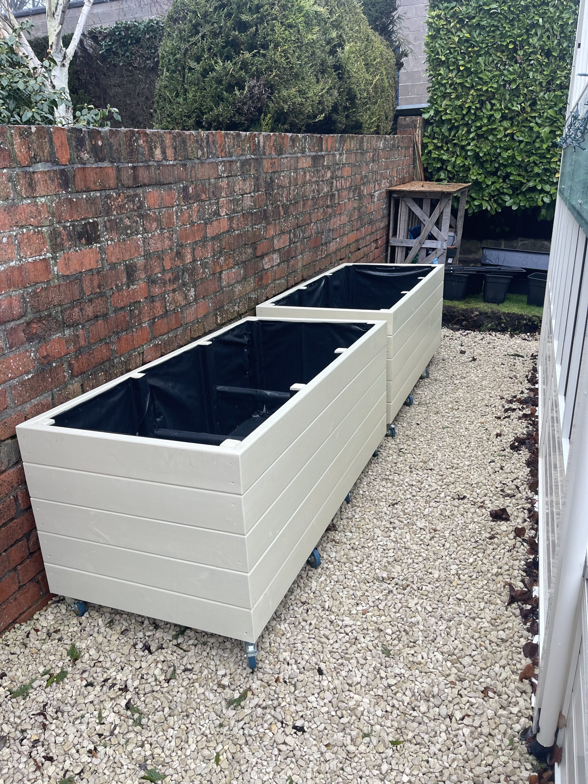 Wooden planters used to define an outdoor walkway and seating area